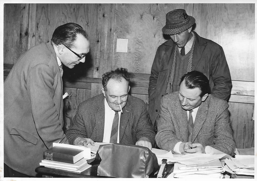 Percy Nunn, who was Office Manager at Justin Brooke Ltd. Harold Burton is seated (with his cigarette) He was Director of the fruit growing side of the business, Robert Nightingale was Company Secretary and David Lee, who ran the arable farm and livestock, is standing